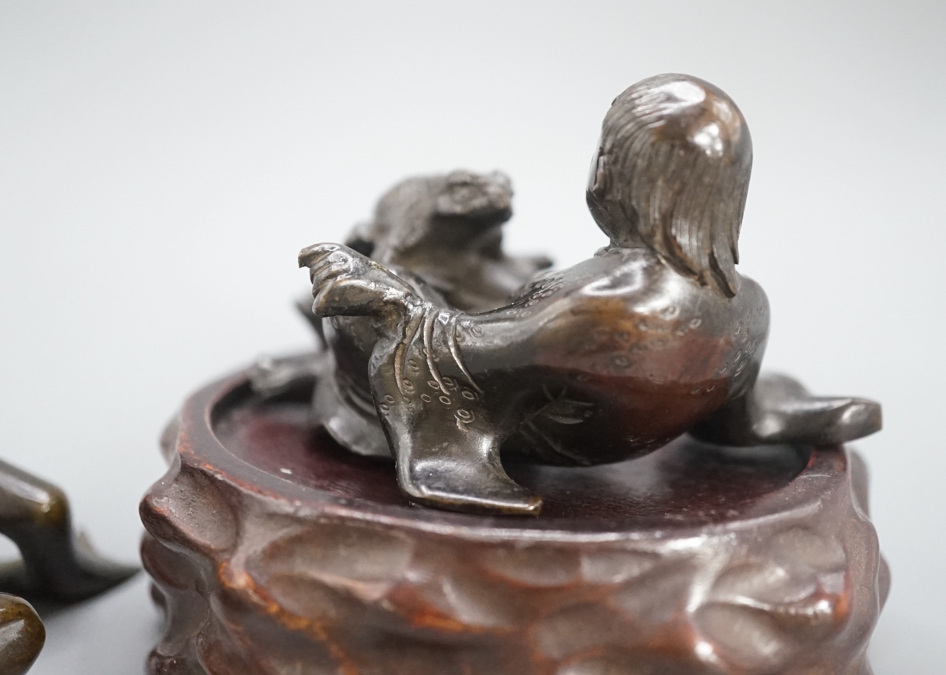 A Chinese bronze group of Liu Hai and a toad, wood stand and a bronze figure of a dog, 9cm
